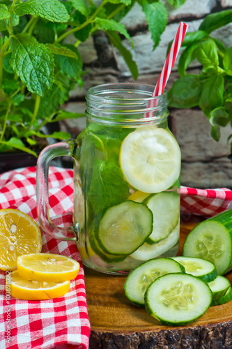 Water with lemon, mint and cucumber on wooden background. Water Detox.