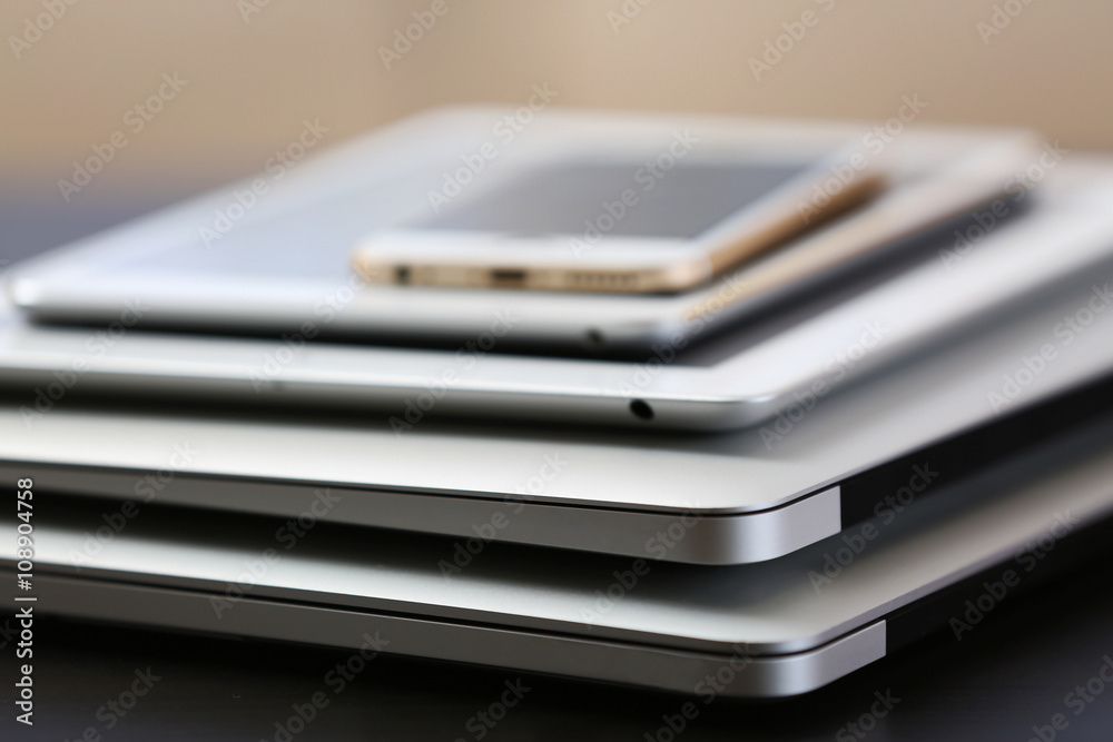Stack of electronic devices on a dark desk