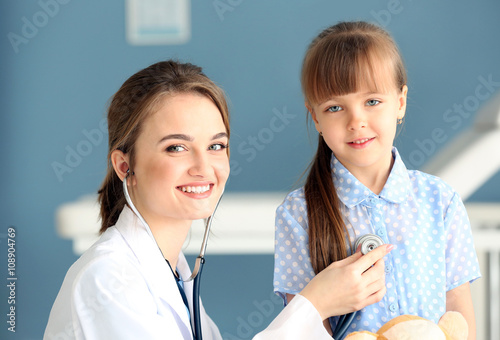 Doctor examining girl with ...