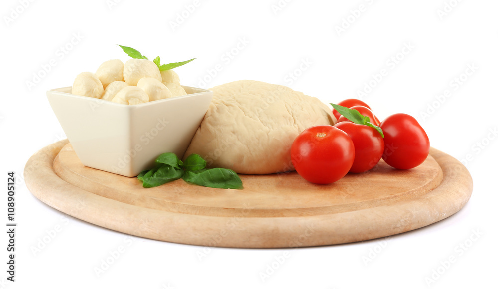 Fresh dough and other different ingredients for pizza on cutting board isolated on white