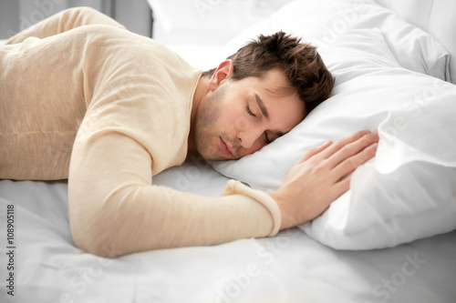 Dressed man sleeping on the bed.