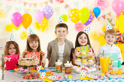 Happy group of children with gift boxes at birthday party