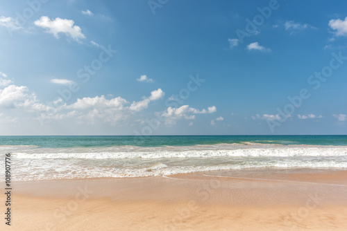 tropical beach and wave against blue sky background