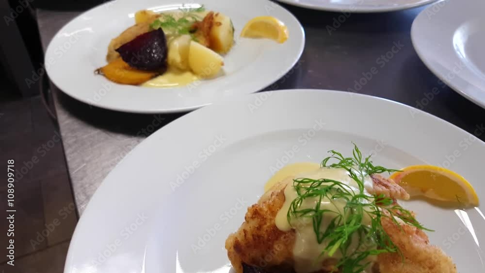 Battered perch filet dishes, with, dill, golden beetroot, potatoes and hollandaise sauce, at a restaurant kitchen Battered perch filet dishes, with, dill, golden beetroot, potatoes and hollandaise sauce, at a restaurant kitchen