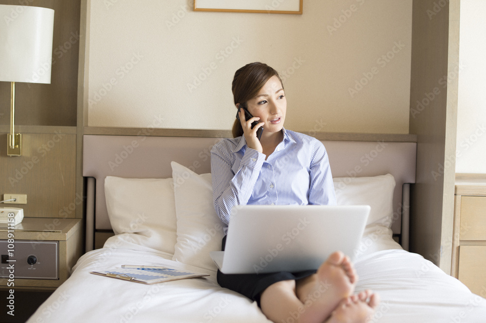 Women are talking on the phone sitting in a business hotel bed Women are talking on the phone sitting in a business hotel bed