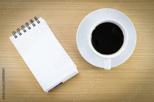 Coffee and notepad on wood table