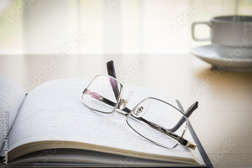  Eyeglasses put on a book with on the desk