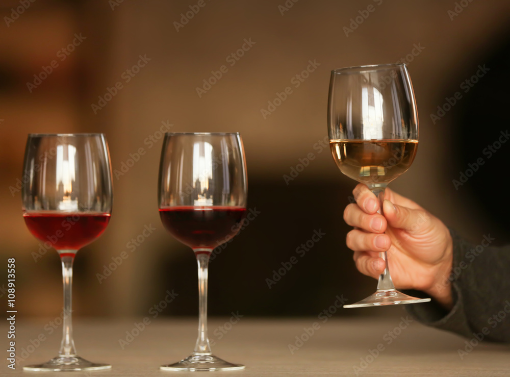 Man holding white wine in a glass at the table