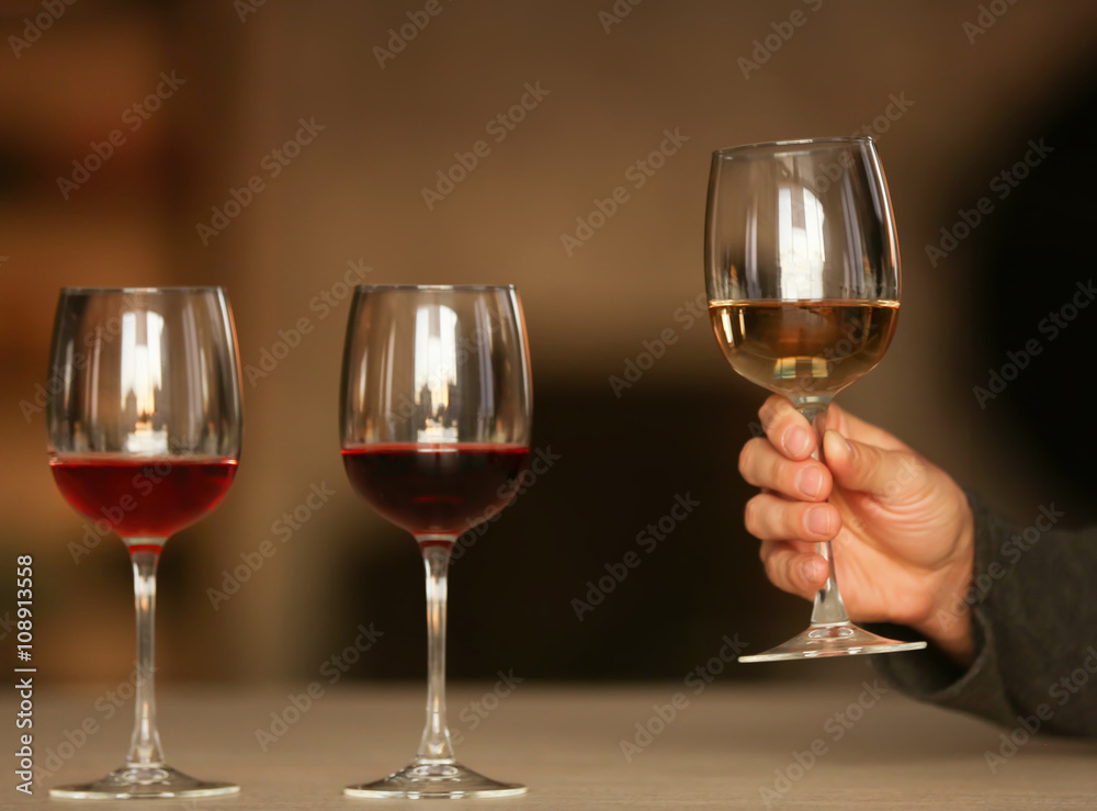 Man holding white wine in a glass at the table Man holding white wine in a glass at the table