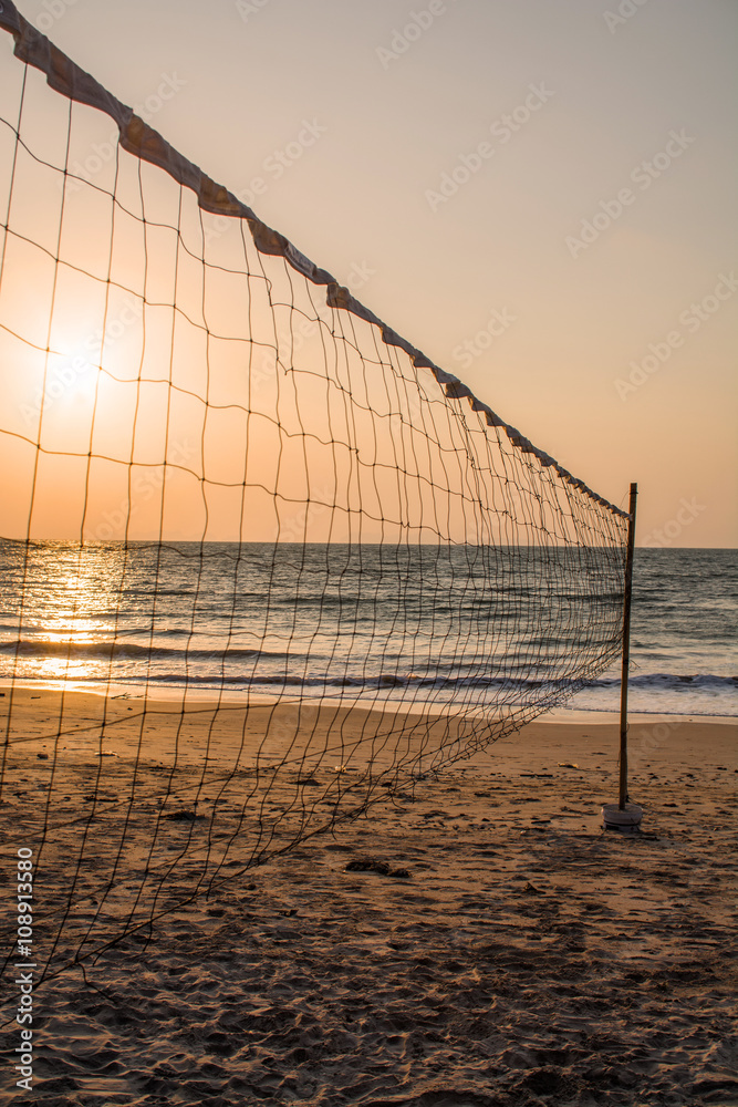 Volleyball net on the beach at sunset time Volleyball net on the beach at sunset time