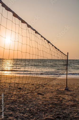 Volleyball net on the beach at sunset time