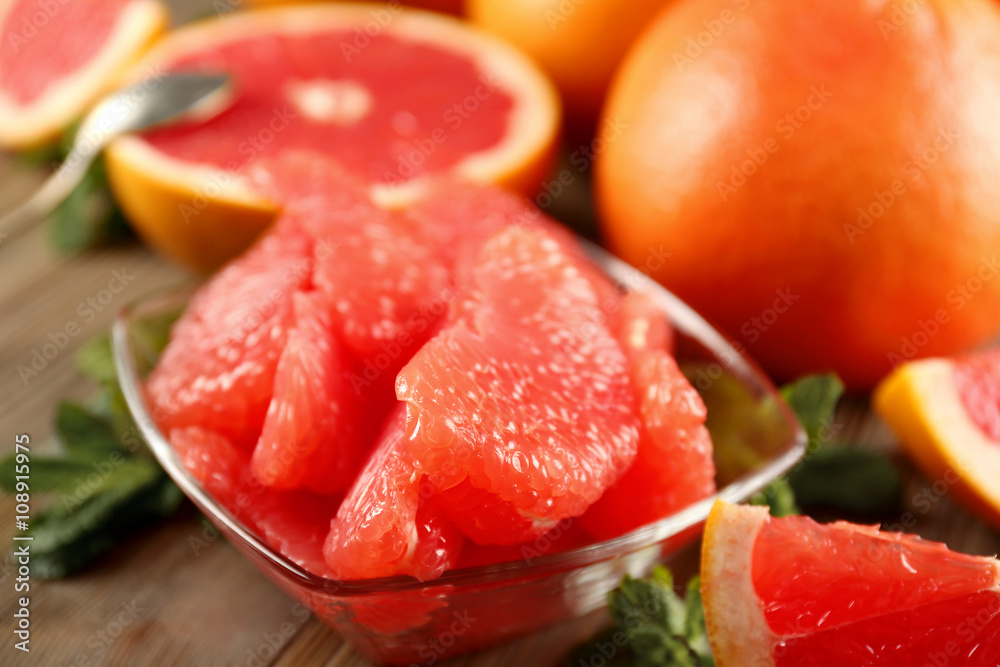 Juicy grapefruit pieces with fresh mint in a bowl, close up Juicy grapefruit pieces with fresh mint in a bowl, close up