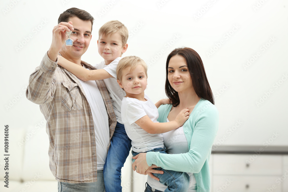 Happy family with key in new house, indoor Happy family with key in new house, indoor