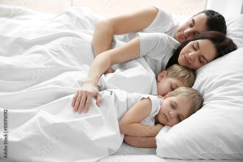 Family sleeping in bed, closeup photo