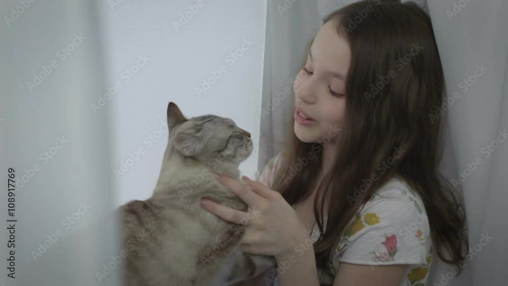 Beautiful little girl tenderly stroking her cat. Beautiful little girl tenderly stroking her cat.