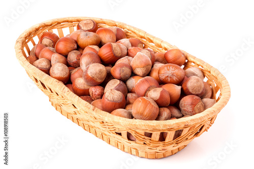 hazelnuts in a wicker basket isolated on white background
