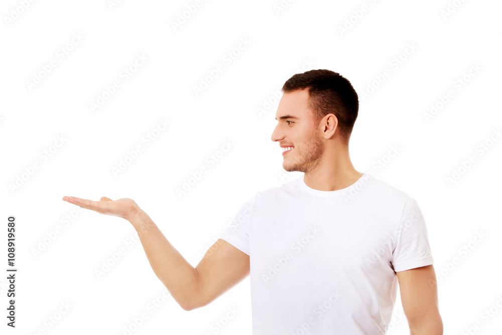Young man showing something on palm Young man showing something on palm