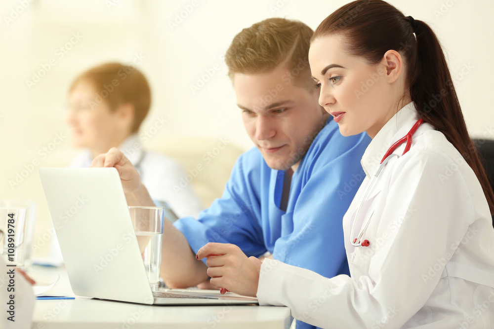 Medical doctors sitting at the meeting in modern hospital Medical doctors sitting at the meeting in modern hospital