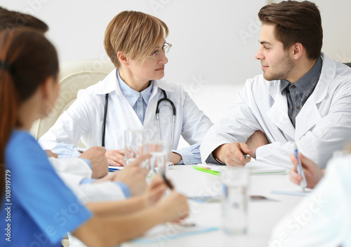 Medical doctors sitting at the meeting in modern hospital