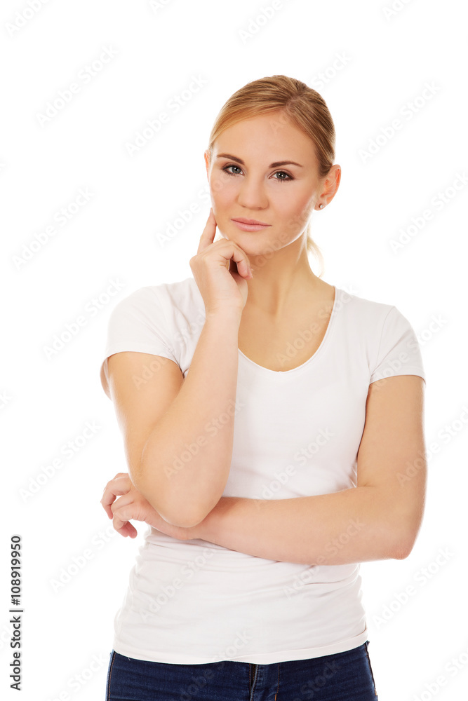 Young woman with folded hands and finger on cheek Young woman with folded hands and finger on cheek