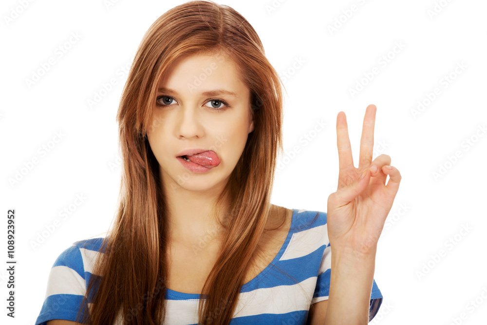 Smiling young woman showing the victory sign Smiling young woman showing the victory sign