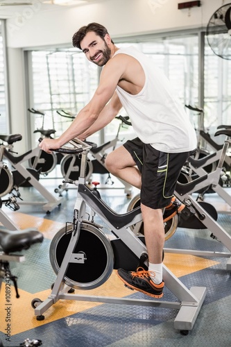 Fit man using exercise bike