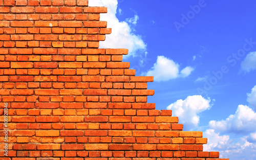 Damaged brick wall and blue sky