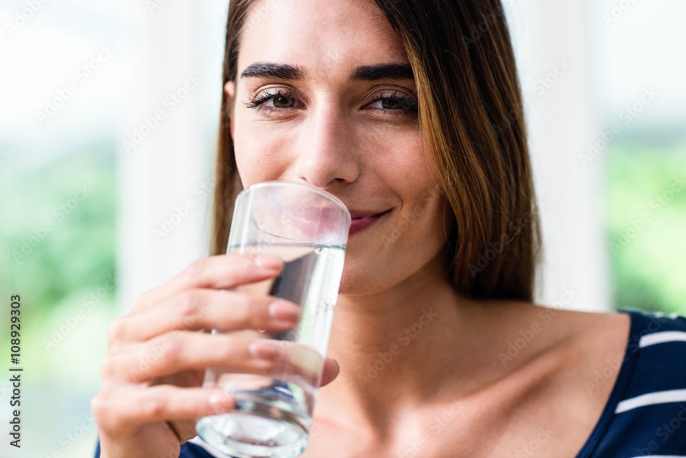 Portrait of smiling young woman drinking water Portrait of smiling young woman drinking water
