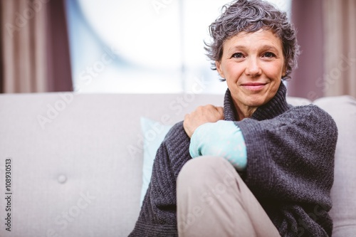 Portrait of smiling mature woman sitting on sofa 