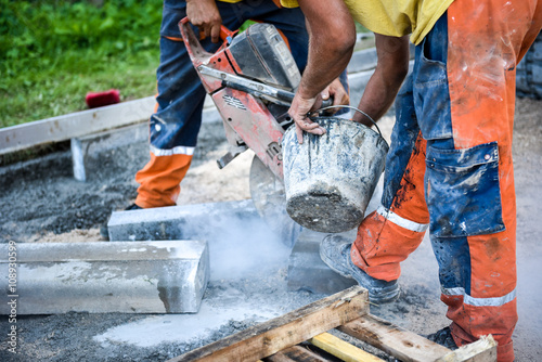 Construction worker cutting concrete paving stabs or metal for s photo