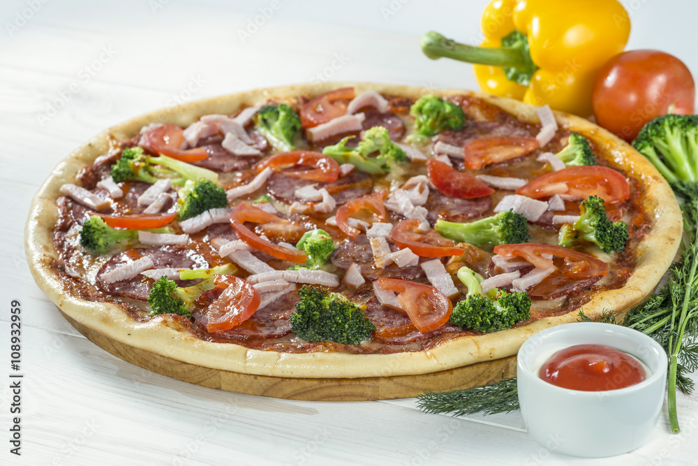 tasty pizza on a wooden board with beautiful vegetables and sauc
