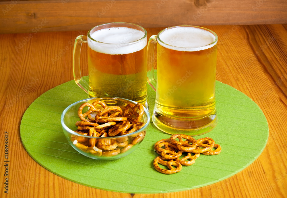 Bowl of pretzels and two mugs of beer Bowl of pretzels and two mugs of beer