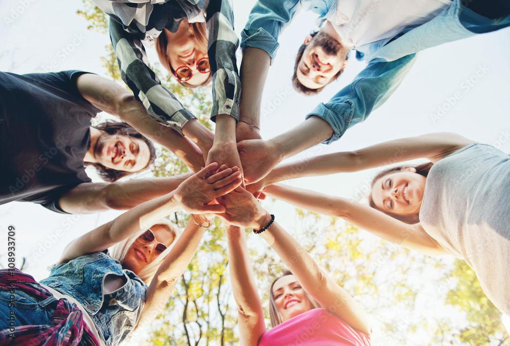 Group of young people standing in a circle, outdoors, having fun, hands Group of young people standing in a circle, outdoors, having fun, hands