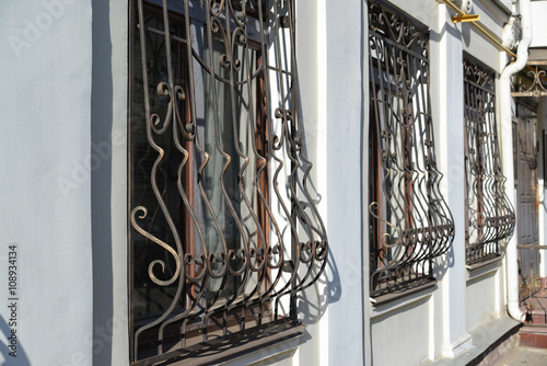 Fotografie Metal wrought-iron bars on  windows of apartment house