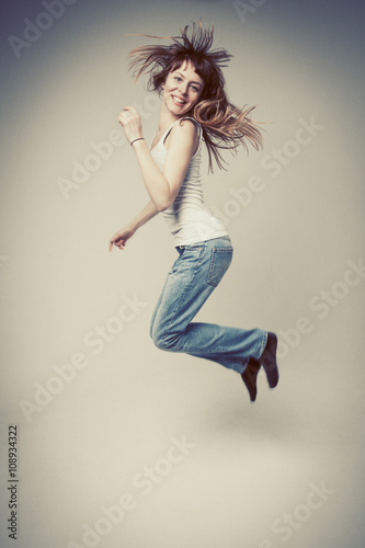 young woman is happy, her face expresses pleasure on a gray back © igorp17