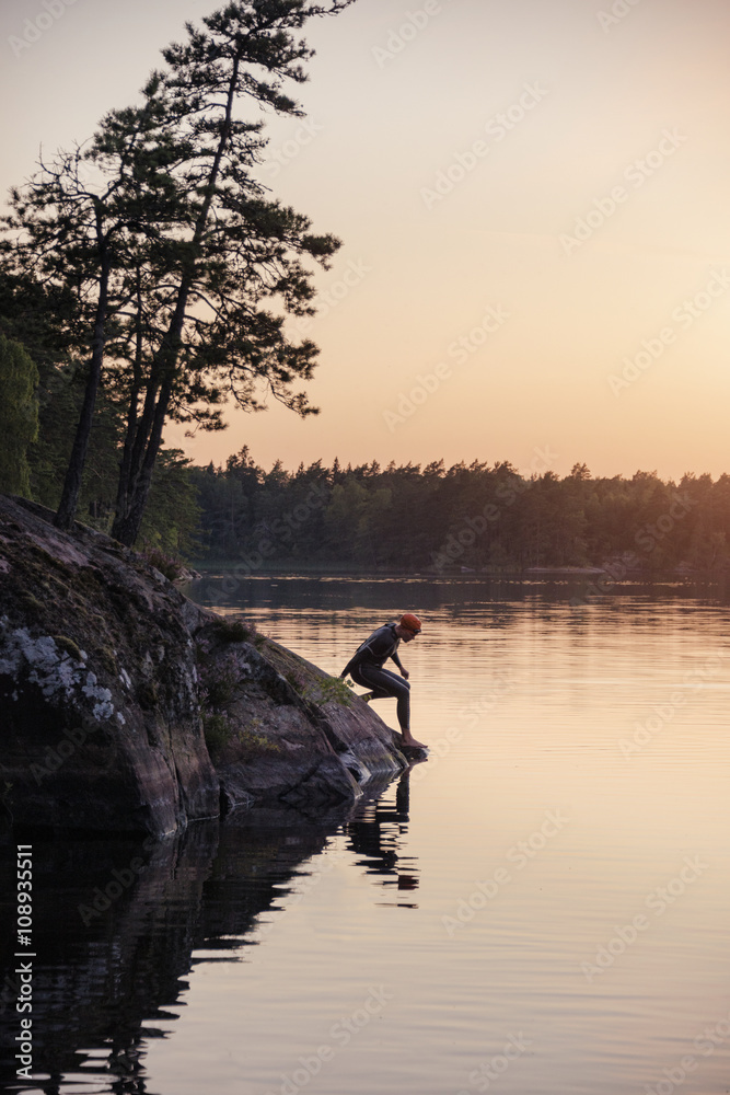 Swimmer at water, sunset