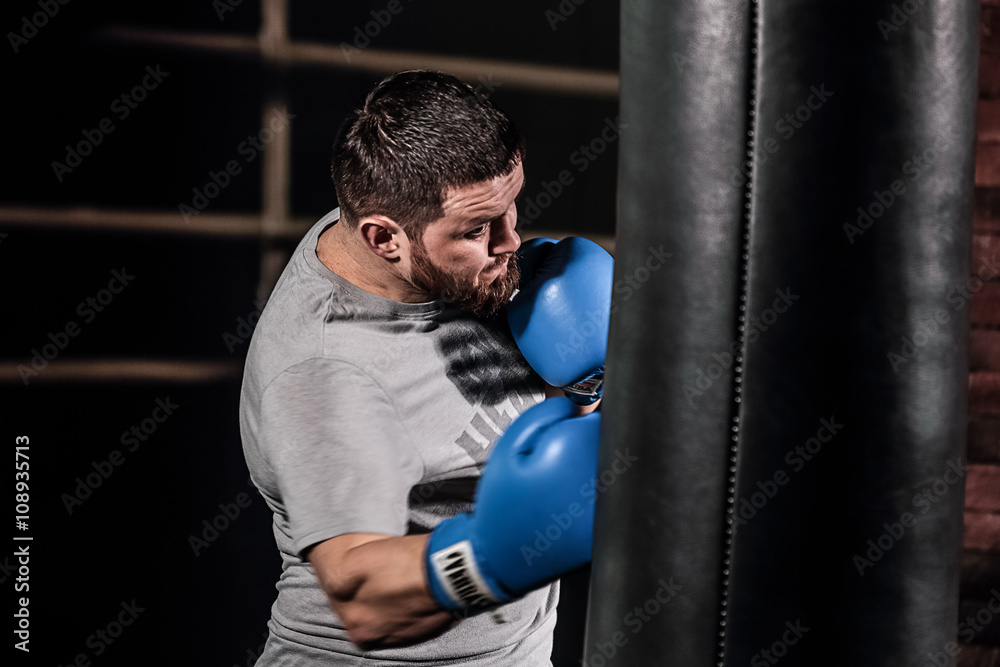 Portrait of Boxer boxing with punching bag. The athlete trains and prepares for boxing.