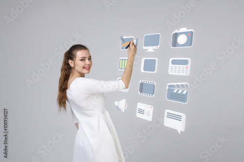 Woman pressing high tech type of modern multimedia buttons on a virtual background