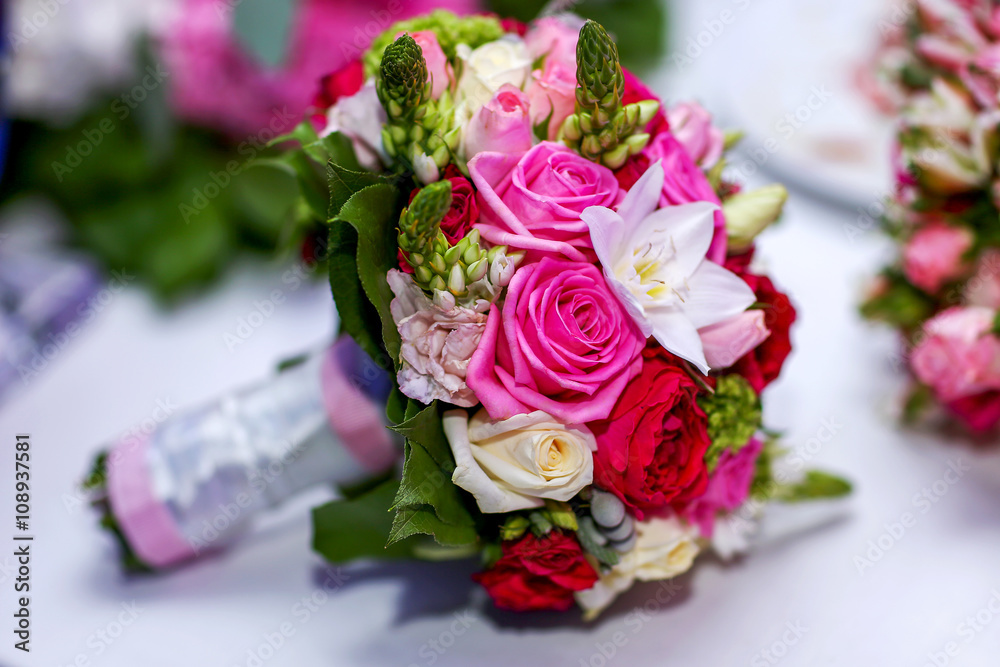 Wedding bouquet of bride colorful roses on the white table Wedding bouquet of bride colorful roses on the white table