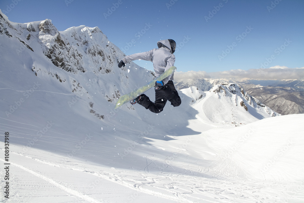 Snowboard rider jumping on mountains. Extreme snowboard freeride sport. Snowboard rider jumping on mountains. Extreme snowboard freeride sport.