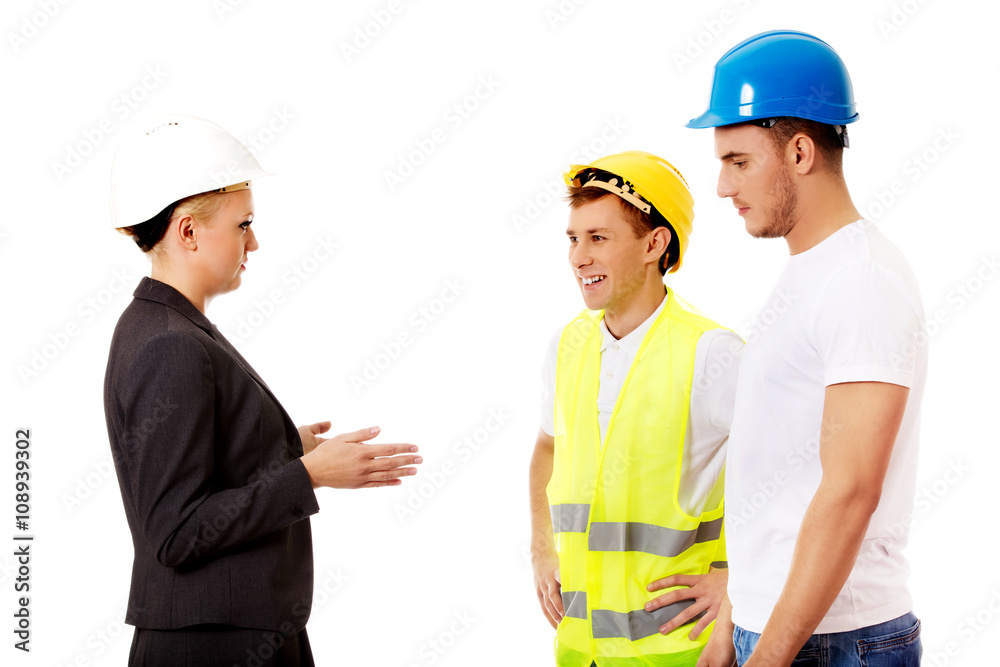 Female engineer talking with two builders Female engineer talking with two builders