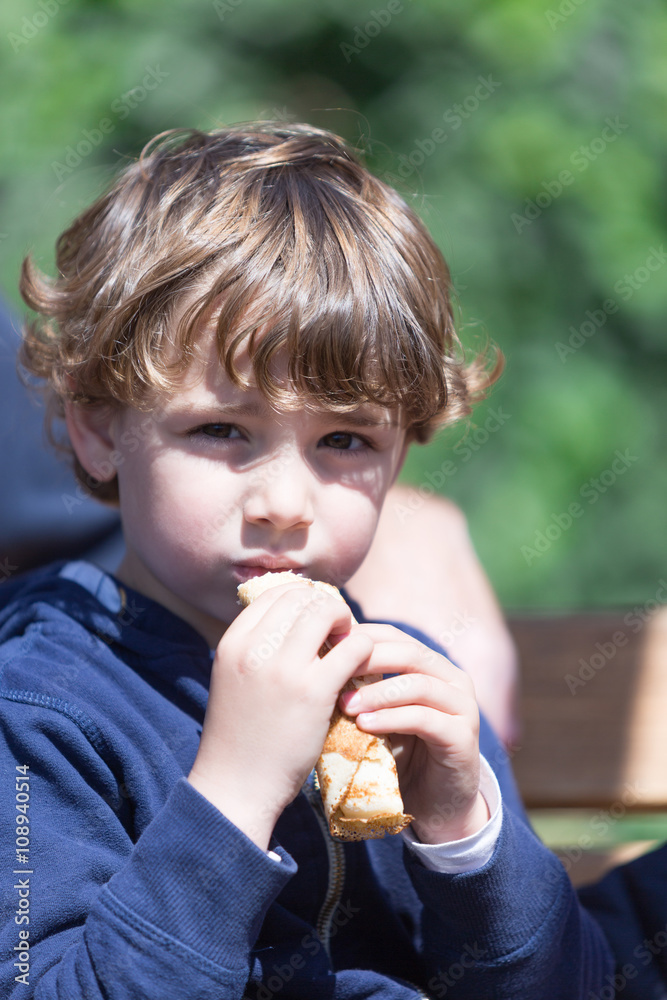 Cute little boy eating pancake outdoor Cute little boy eating pancake outdoor