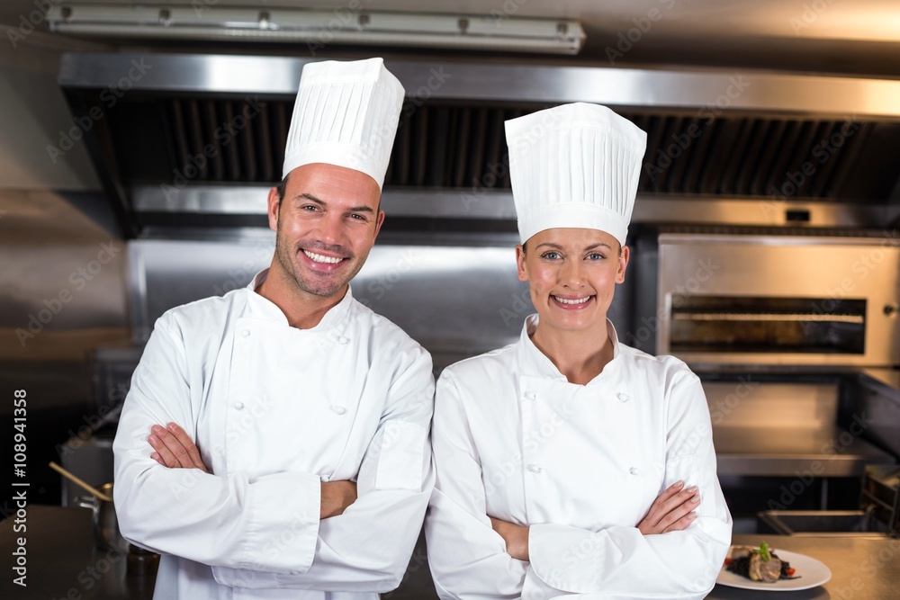 Portrait of happy chefs standing in kitchen