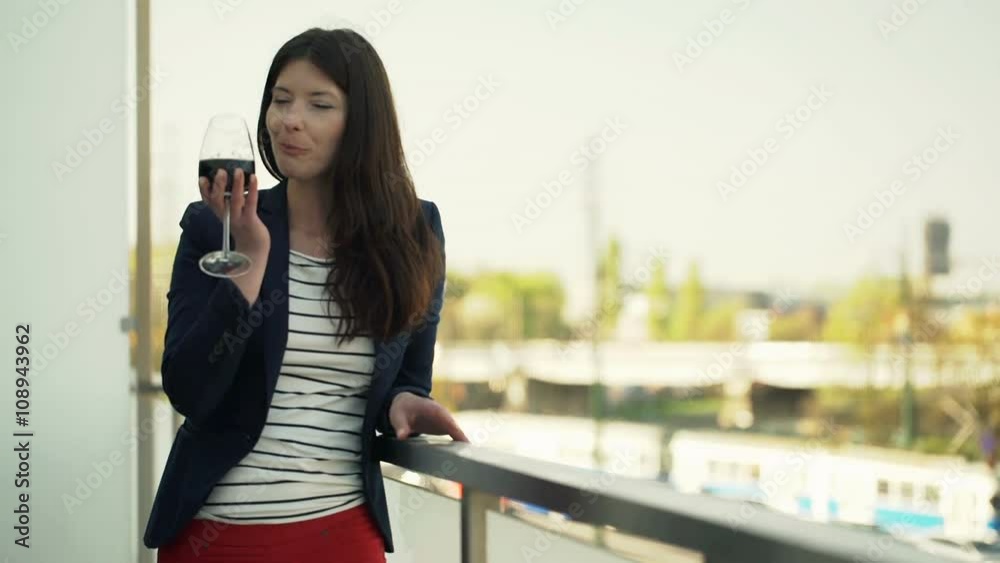 Happy woman drinking red wine standing on terrace
Happy woman drinking red wine standing on terrace