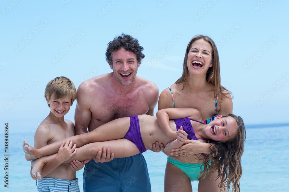 Cheerful family lifting girl at sea shore Cheerful family lifting girl at sea shore