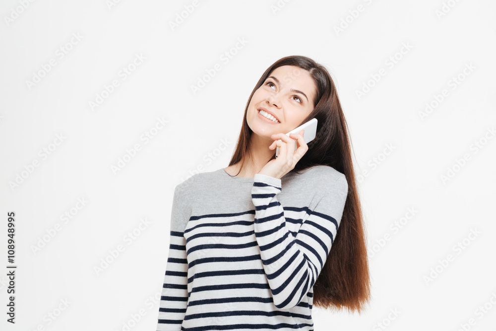 Smiling woman talking on the phone and looking up Smiling woman talking on the phone and looking up