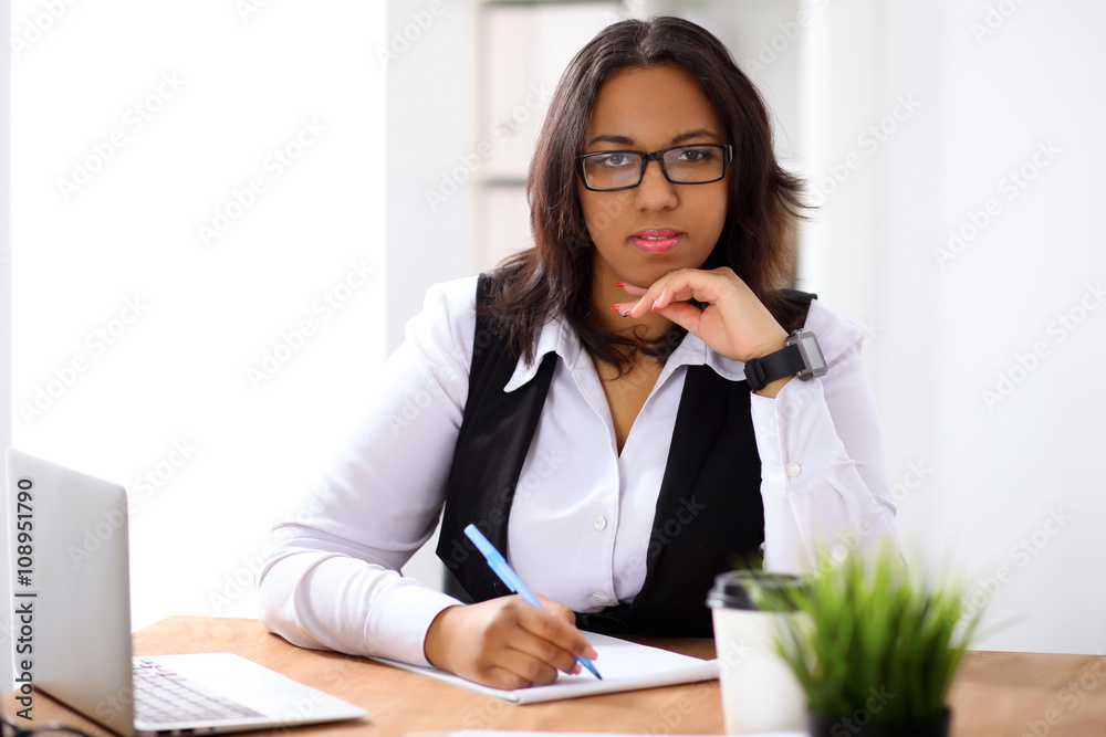 African american business woman is busy with paper job in office while sun shines outdoors African american business woman is busy with paper job in office while sun shines outdoors