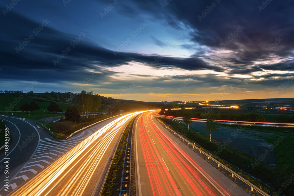 Long-exposure sunset over a highway - obrazy, fototapety, plakaty 