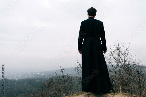 Canvastavla Portrait of handsome catholic bearded man priest or pastor posing outdoors in mo