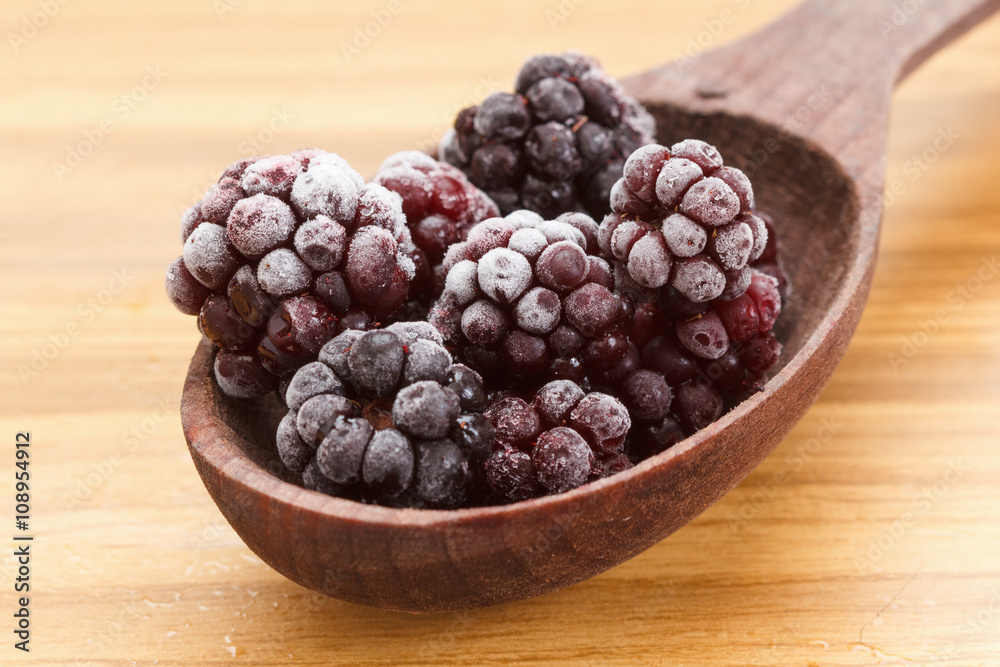 Macro view on frozen Blackberry fruits in spoon Macro view on frozen Blackberry fruits in spoon